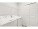 Convenient laundry room includes appliances, shelving, and closet space at 5213 Patano Loop, Palmetto, FL 34221