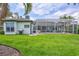 Expansive backyard and green lawn with covered lanai and in-ground pool at 5285 Far Oak Cir, Sarasota, FL 34238