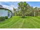 Spacious backyard with mature trees and lush green lawn providing ample space for outdoor activities at 5285 Far Oak Cir, Sarasota, FL 34238