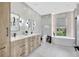 Modern bathroom features double vanity, standalone tub, and sleek gray tile work at 5285 Far Oak Cir, Sarasota, FL 34238