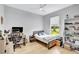 Cozy bedroom with light wood floors, a ceiling fan, and a large window at 5285 Far Oak Cir, Sarasota, FL 34238