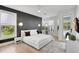 Sunlit main bedroom features an accent wall, large windows, and modern minimalist decor at 5285 Far Oak Cir, Sarasota, FL 34238