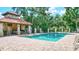 This inviting pool features a covered pavilion with dining area, grill, and lush landscaping at 5285 Far Oak Cir, Sarasota, FL 34238