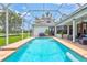 View of sparkling backyard pool with sun shelf and screened-in lanai area at 5285 Far Oak Cir, Sarasota, FL 34238