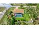 Aerial view of home with screened-in pool, shed, manicured lawn, surrounded by tall trees at 5307 Kenvil Dr, North Port, FL 34288