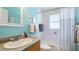 Bright bathroom with blue walls, updated vanity, and shower/tub combo at 5307 Kenvil Dr, North Port, FL 34288