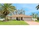 Inviting single-story home featuring a well-manicured lawn, palm tree, and attached two-car garage at 5307 Kenvil Dr, North Port, FL 34288