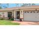 Close up of a charming home featuring a two-car garage, arched windows, and well-maintained landscaping at 5307 Kenvil Dr, North Port, FL 34288