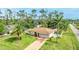A charming single-story home with a well-manicured lawn, a driveway, and mature palm trees at 5307 Kenvil Dr, North Port, FL 34288
