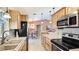Galley kitchen features wooden cabinets, stone countertops, and stainless steel appliances at 5307 Kenvil Dr, North Port, FL 34288