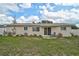 Backyard patio with chair seating in a well-maintained lawn and sliding glass door access to the home at 5412 Skyline Pl, Sarasota, FL 34232