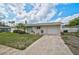 Charming single-story home with a well-maintained lawn, a bright blue door, and an attached garage at 5412 Skyline Pl, Sarasota, FL 34232
