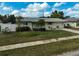 Beautifully landscaped home with a manicured lawn, striking blue door, and lush landscaping at 5412 Skyline Pl, Sarasota, FL 34232