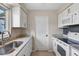 Bright kitchen features white cabinets, granite countertops, and stainless-steel sink at 5412 Skyline Pl, Sarasota, FL 34232
