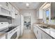 Well-lit kitchen boasting white cabinetry, granite counters, and adjacent dining area at 5412 Skyline Pl, Sarasota, FL 34232