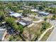 Aerial shot displays the home's roof damage amidst a lush, green neighborhood setting at 5705 23Rd W St, Bradenton, FL 34207