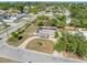 Aerial view of a modest home with overgrown yard, set amongst a neighborhood of mature trees at 5705 23Rd W St, Bradenton, FL 34207