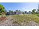View of the overgrown backyard with an open patio and exterior of the home at 5705 23Rd W St, Bradenton, FL 34207