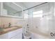 All-white bathroom featuring a tub, toilet, sink with countertop, mirror, and a window for natural light at 5705 23Rd W St, Bradenton, FL 34207