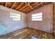 Bedroom with pink walls, natural light from two windows, and damaged floors, ideal for renovation at 5705 23Rd W St, Bradenton, FL 34207