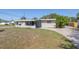 Single-story home with a covered porch, light-blue door, and a front yard in need of landscaping at 5705 23Rd W St, Bradenton, FL 34207