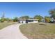 Modest single-story home with overgrown landscaping and a curved driveway at 5705 23Rd W St, Bradenton, FL 34207
