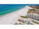 Aerial view of a condo on a pristine beachfront offering a pool, lounging areas, and clear blue waters at 5880 Midnight Pass Rd # 207, Sarasota, FL 34242