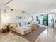 Bright and airy living room featuring a large sectional sofa, stylish decor, and access to a balcony at 5880 Midnight Pass Rd # 207, Sarasota, FL 34242