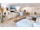 Open-concept living space with travertine flooring, a large TV, and comfortable seating at 5880 Midnight Pass Rd # 207, Sarasota, FL 34242