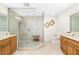 Elegant bathroom with walk-in glass shower, marble countertops and wood cabinets at 610 Riviera Dunes Way # 503, Palmetto, FL 34221