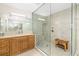 Elegant bathroom with a glass-enclosed shower, wood vanity with granite countertop, and decorative mirror at 610 Riviera Dunes Way # 503, Palmetto, FL 34221