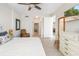 Bedroom featuring decorative mirror, white dresser, and an ensuite bathroom at 610 Riviera Dunes Way # 503, Palmetto, FL 34221
