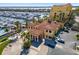 Elegant clubhouse with covered entrance, tile roof, palm trees, ample parking, and marina in background at 610 Riviera Dunes Way # 503, Palmetto, FL 34221