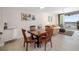 Cozy dining area with wooden furniture, bright lighting, and a view of the balcony with water views at 610 Riviera Dunes Way # 503, Palmetto, FL 34221