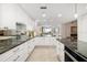Modern kitchen featuring white cabinets, sleek countertops, and a seamless flow into the living area with a view at 610 Riviera Dunes Way # 503, Palmetto, FL 34221
