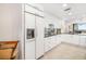 Bright kitchen with white cabinets, stainless steel fridge, and an adjacent sitting area at 610 Riviera Dunes Way # 503, Palmetto, FL 34221
