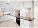 Modern kitchen featuring white cabinets, granite countertops, a built-in oven, and bright interior lighting at 610 Riviera Dunes Way # 503, Palmetto, FL 34221