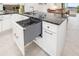 Island of a modern kitchen featuring white cabinets, granite countertops, and an undermount dishwasher at 610 Riviera Dunes Way # 503, Palmetto, FL 34221