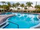 Inviting outdoor swimming pool with lounge chairs and palm trees, perfect for relaxation at 610 Riviera Dunes Way # 503, Palmetto, FL 34221