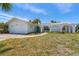 Charming single-story home with white exterior, arched entryway, and well-maintained front lawn at 6203 11Th W Ave, Bradenton, FL 34209