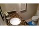 Compact powder room with a marble countertop and neutral decor at 6300 Flotilla Dr # 108, Holmes Beach, FL 34217