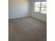 Empty bedroom showcasing neutral carpet and natural light from the window at 6300 Flotilla Dr # 108, Holmes Beach, FL 34217