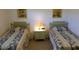 Cozy bedroom featuring two twin beds with matching floral bedding and a shared nightstand at 6300 Flotilla Dr # 108, Holmes Beach, FL 34217
