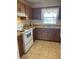 Traditional kitchen with brown wood cabinets, white appliances and tile flooring at 6300 Flotilla Dr # 108, Holmes Beach, FL 34217