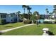 Community pool surrounded by mature landscaping, an American flag, and lawn at 6300 Flotilla Dr # 108, Holmes Beach, FL 34217