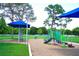 Community playground with colorful equipment, shade structures, and a mulch base, perfect for Gathering fun at 6704 Rosemary Dr, Tampa, FL 33625