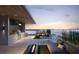 Stunning rooftop deck with outdoor kitchen, lounge seating, and panoramic water views at sunset at 688 Golden Gate Point # 201, Sarasota, FL 34236