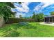 Private backyard with a splash pool, lush green lawn, mature trees, and a wooden fence providing seclusion at 7023 Woodside Oaks Cir # 1, Sarasota, FL 34231