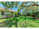 Lush backyard garden with mature trees provides shade and privacy with plants at 7023 Woodside Oaks Cir # 1, Sarasota, FL 34231