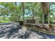 Entrance sign for Woodside Oaks with mature trees lining the street at 7023 Woodside Oaks Cir # 1, Sarasota, FL 34231
